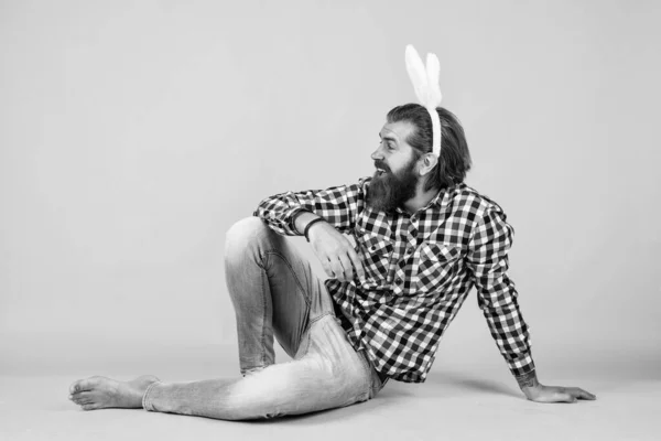 funny bunny. happy easter. funny bearded man wear bunny ears. guy in rabbit costume having fun. spring holiday party celebration. egg hunt. brutal happy man on yellow background.