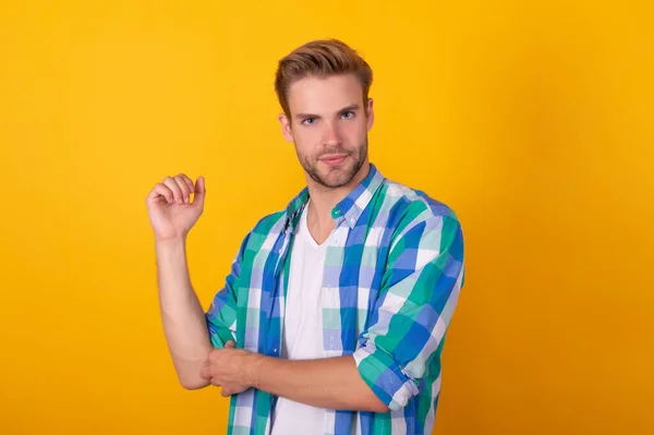 Just cool dude. Handsome dude portrait. Young man roll up shirt sleeves. Serious guy yellow background.