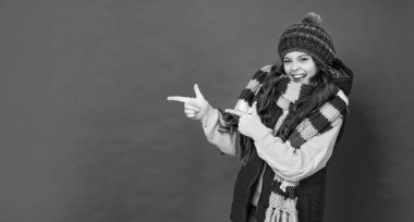 Kopyalama alanını işaret ediyor. Şapkalı, kıvırcık saçlı mutlu çocuk. Kadın manken. Eşarplı genç kız. Kalın giysiler giyen çocuk portresi. Olumlu duygularını ifade et. kış modası.