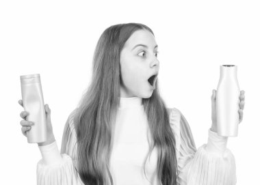 Şaşırmış bir çocuk sunuyor şampuan ya da saç kremi şişesi beyaz, güzellik kozmetik izole.