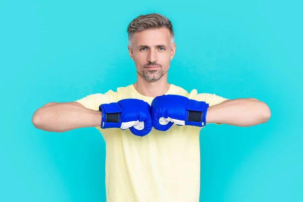 man boxer fighter in sport boxing gloves on background. photo of man boxer in sport boxing gloves. man boxer in sport boxing gloves isolated on blue. man boxer in sport boxing gloves at studio.