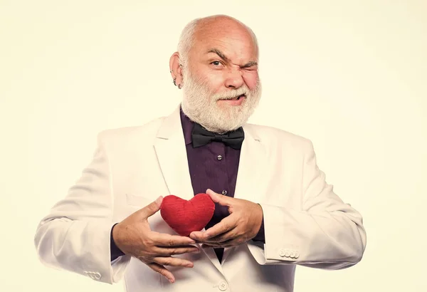 Healthy life. Mature man with valentines heart. Heart and healthcare. Diagnostics and treatment. Health care. Preventing heart attack. Senior bald head bearded man holding red toy heart in hands.