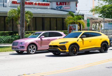 Miami Beach, Florida ABD - 15 Nisan 2021 Bentley Bentayga v8 2015 ve Giallo Auge Lamborghini Urus.