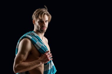 Üstsüz, kaslı, havluyla fotokopi çeken adam. Gömleksiz bir adamın kaslı kasları olduğu fotoğraf. Siyah arka planda havlusu olan kaslı üstsüz bir adam. Gövdesi kaslı, üstsüz bir adam.