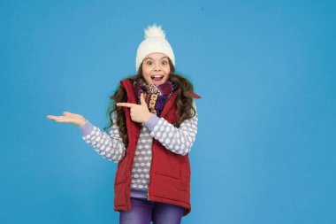 Sıcak kış kıyafetleri içinde neşeli bir çocuk. Yeni yıl tatilinde örgü şapka ve kazak giyer. Ürün sunar, reklam için fotokopi alanı, xmas alışverişi..