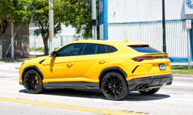 Miami Beach, Florida USA - April 15, 2021: 2019 Yellow Giallo Auge Lamborghini Urus, back corner view.