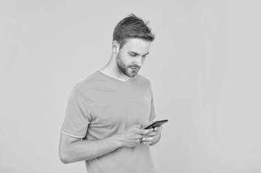 guy with bristle chatting on smartphone on yellow background, technology.