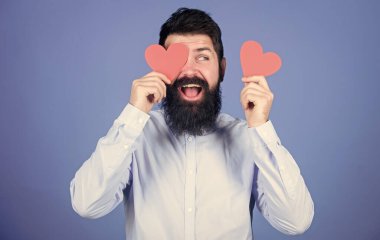 Sevgililer günün kutlu olsun. Sakallı adam, kırmızı kalpli bir göz saklıyor. Hippi küçük kalpler tutuyor. Kalp şeklinde kartları olan seksi bir sevgililer günü erkeği. Aşk ve romantizm bayramı. Aşk mutluluğun anahtarıdır..