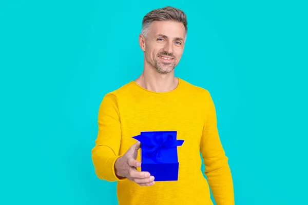 happy man shopper with present isolated on blue. man shopper with present in studio. man shopper with present on background. photo of man shopper with present.