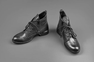 Mavi arka planda ayak bileği çizmeleri. Ayakkabı dükkanı. Alışveriş konsepti. Kadın derisi şık ayakkabılar. Bir çift şık deri ayakkabı..