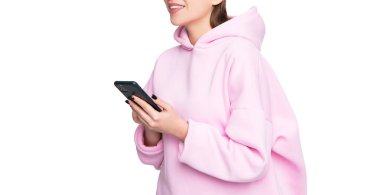 Mutlu kadın, beyaz sosyal ağda izole edilmiş akıllı telefon kullanarak günlük pembe kapüşonlu gözlük takıyor..