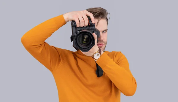 man photographer take picture with camera in studio. man photographer with photo camera. photo of man photographer with camera. man photographer with camera isolated on grey background.