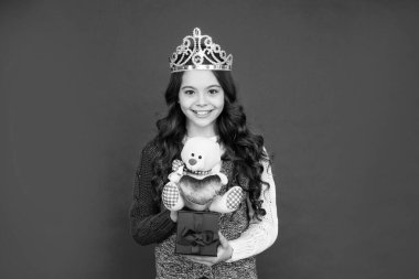 Kraliçe tacındaki mutlu çocuk. Tacın içindeki prenses. Hediyesi olan çocuk. Genç kız kırmızı arka planda Diadem oyuncağı giyiyor..