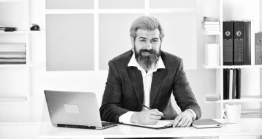 Özgüven ve karizma. Patron iş yerinde. Modern ofis hayatı. Coronavirüs karantinadayken uzak çalışma. Olgun öğretmen. İş odaklı iş adamı. Laptoplu, ceketli sakallı adam..