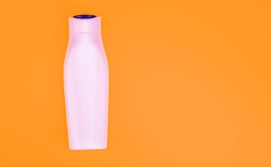 Saç kremi ya da vücut losyonu. Günlük alışkanlık ve kişisel bakım. Sarı arka planda cilt güzellik kozmetiği. kopyalama alanı. Kozmetik ürünleri sunuyorum. markasız şampuan reklamı.