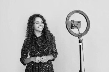 Uzun kıvırcık saçlı çocuk gülüşü blog için video yapıyor.