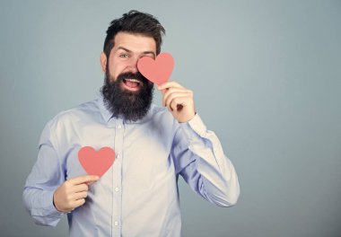 Celebrate love. Guy attractive with beard and mustache in romantic mood. Feeling love. Dating and relations concept. Falling in love. Happy in love. Man bearded hipster with heart valentine card.