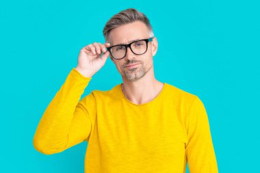 mature man look in eyewear on background. photo of man look in eyewear. man look in eyewear isolated on blue. man look in eyewear at studio.
