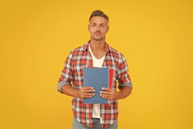 Okul kitaplarındaki mutlu adam sarı arka planda, öğretmenim..