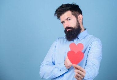Celebrate love. Guy attractive with beard and mustache in romantic mood. Feeling love. Dating and relations concept. Happy in love. Falling in love. Man bearded hipster with heart valentine card.