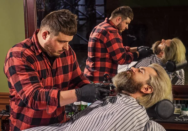 Making hair look magical. male beauty and fashion. mature man at barbershop. brutal bearded man at hairdresser. barber with male client. hipster with dyed beard and moustache. man want new hairstyle.
