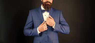 Mavi smokinli papyonlu kırpık adam. Siyah arka planda resmi giyinmiş bir beyefendi. erkek resmi moda.