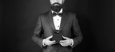 Smokinli, papyonlu, siyah arka plan gözaltı kutusunda kesilmiş bir adam. Alışveriş satışı.