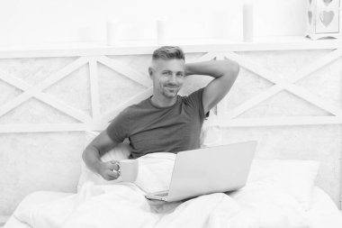 Mutlu adam rahatlayıp kahve içiyor ve sabahları dizüstü bilgisayar kullanıyor, dinleniyor..