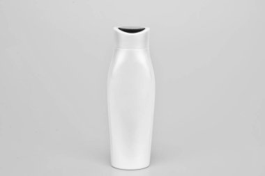 Sarı arka planda beyaz şampuan şişesi, cilt bakımı.