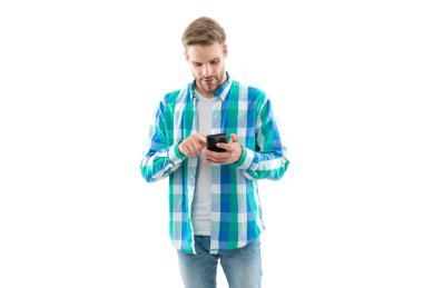 caucasian man texting on phone isolated on white background. casual man texting on phone in studio. man texting on phone wearing checkered shirt. photo of man texting on phone device.