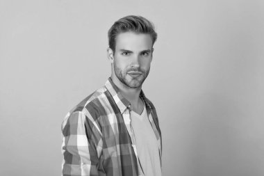 İşaretli gömlekli, ciddi bir genç portresi. Sarı arka plan, yakışıklı..