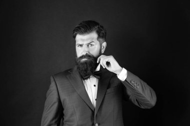 Smokinli, papyonlu, zengin bir adam. Siyah arka planda resmi giyinen bir adam. erkek resmi moda.