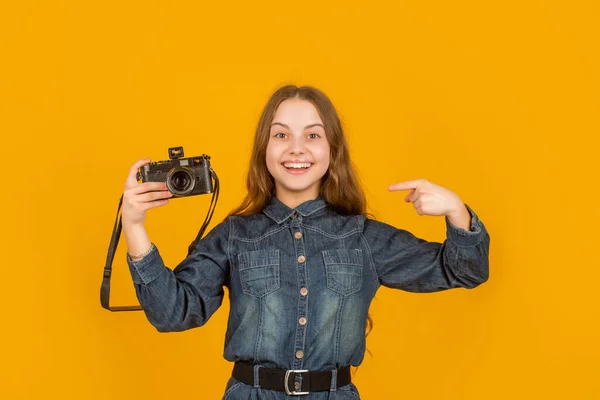 Happy teenage girl pointing finger at camera. Teenage photographer with advertising gesture. Advert.