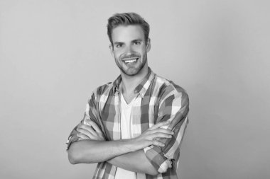 Kendine güvenen bir gülümseme. Özgüvenli adam sarı arka plan portresi. Kollarını kavuşturan mutlu adam. Gülümseyen güven.