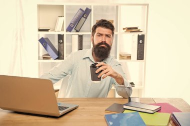 Ofis masasında oturup kahve içmekten bıkmış profesyonel bir adam..