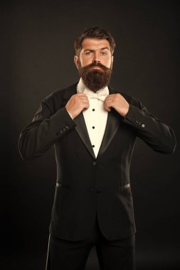 Smokinli zarif uşak siyah arka planda, papyonlu..