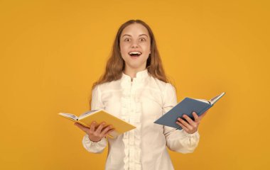 Şaşırmış çocuk kitabı okuyor. Okula dönüyorum. Çocukluk eğitimi. Bilgi günü. Çocuk defteri tut. Lise öğrencisiydim. Genç kız ödevlerini defterle yapıyor. çalışma kitabıyla çalış.