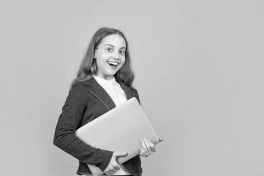 Yeşil arka planda dizüstü bilgisayarı olan mutlu çocuk.