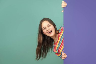 Boş mavi kağıdın arkasında reklam için fotokopi alanı olan gülen çocuk..