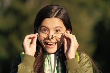 Sırt çantalı hayret verici çocuk gözlük takıyor. Okula geri dön..