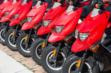 Kiralık motosiklet kırmızısı, üst manzara. Kiralık motosikleti dışarıda park etmiş. Park halindeki kiralık motosikletin fotoğrafı. park edilmiş kiralık motosiklet satırı.