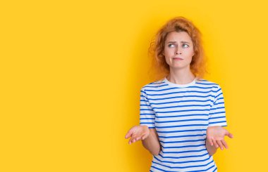 puzzled redhead woman portrait isolated on yellow background. portrait of young redhead woman in studio. adult redhead woman portrait.