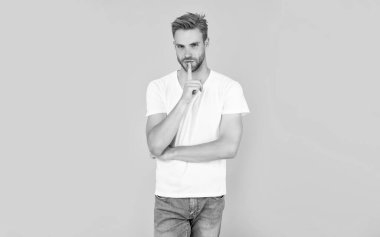 Tüylü adam sarı arka planda sır saklıyor, yaşam tarzı.