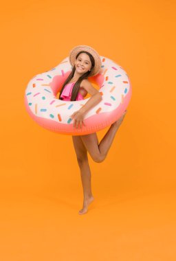 Havuzda şişme lastik halkalı bir kız. Küçük kız suda oynamaya gidiyor. Çocuk yüzme yüzüğü. Yazın açık hava aktivitesi. Mayo giymiş bir çocuk. Neşeli yüzücü denizde dinleniyor.