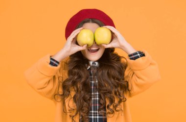 Elma yemek öğrenmeyi geliştirir. Küçük çocuğun elinde elma sarısı bir arka plan var. Küçük kız yeşil elmalarla eğleniyor. Meyve ve vitamin. Elma mevsimi geldi. Okul zamanı. Sonbahar.