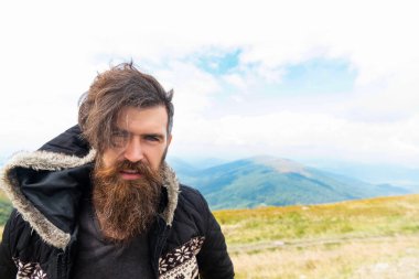 Dışarıdaki sakallı adam, reklam. Sakallı adamın sakalı var. Bıyıklı sakallı adam. Dağdaki sakallı adamın fotoğrafı..