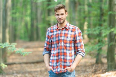 Tarz sahibi beyaz adamın sakalı var. Kareli gömlek giyen beyaz bir adam. Ormandaki beyaz bir adamın fotoğrafı. Kafkasyalı adam dışarıda..