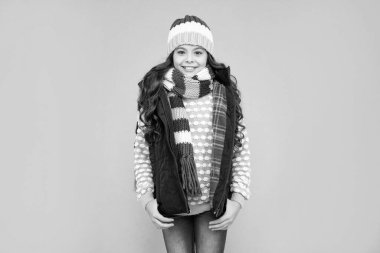 Mavi arka plandaki duygusal genç kız. Kalın giysiler giyen çocuk. Olumlu duygularını ifade et. Kış modası. Şapkalı ve atkılı mutlu çocuk..