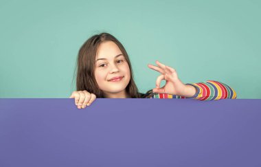 Boş mavi kağıdın arkasında reklam için fotokopi alanı olan mutlu çocuk..