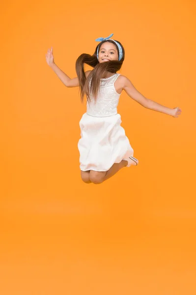 Freedom. Kid full of energy jumping enjoy long healthy hair. Cute hairstyle. Happy childhood. Carefree baby. Beautiful hairstyle. Daily hairstyle for girls. Jumping in mid air. Light and easy.